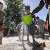 Børnehavebørn leget med vand og spand på børnehusets legeplads