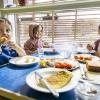 Tre børn spiser frokost i børnehuset Søndergården