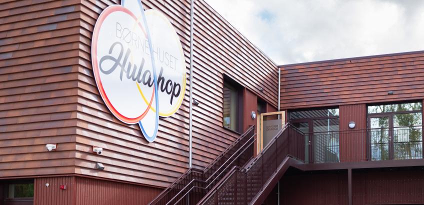 Indgang til børnehuset hulahop med to trapper på hver sin sin længe og træfacade.